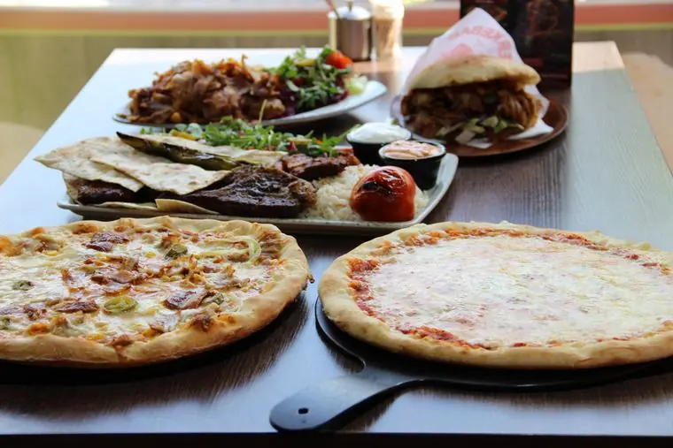 Döner, Grillteller und zwei Pizzen auf einem Tisch